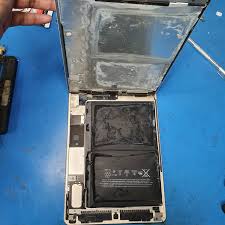 "Certified technician performing microscopic repair on water-damaged iPad logic board in clean room environment"